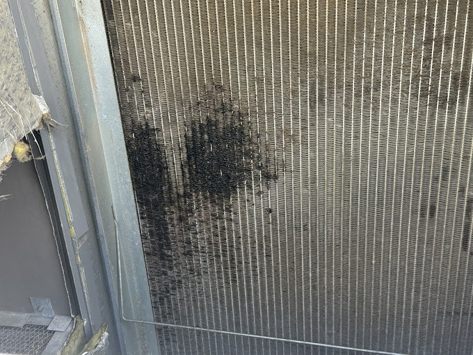 Grime-clogged air conditioner condenser coil restricting airflow, found during a Texas Heatwave AC repair diagnostic