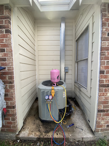 Texas Heatwave technician charging and commissioning a newly installed residential air conditioning condenser with a gauge manifold