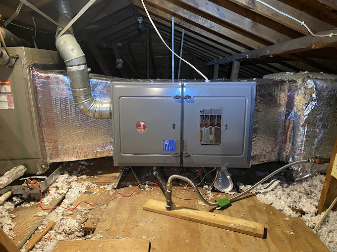 Newly installed Rheem air handler connected to insulated ductwork in an attic during a Texas Heatwave AC system replacement