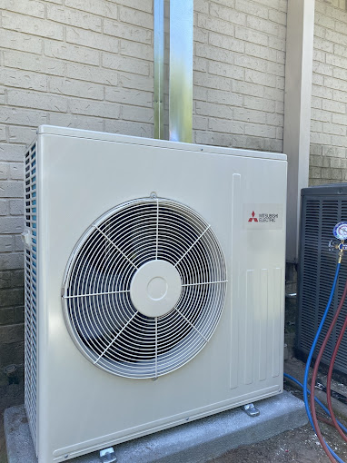 Clean Mitsubishi heat pump outdoor unit installed beside a brick home by Texas Heatwave in the Rio Grande Valley
