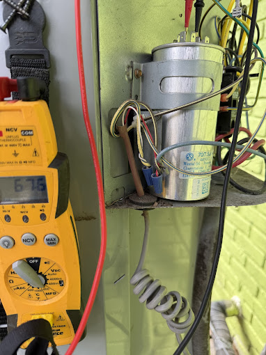 Texas Heatwave AC and Heating technician testing an AC capacitor during an HVAC repair in Spring, TX