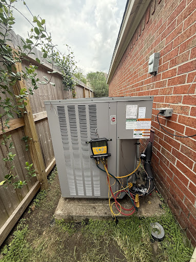 Texas Heatwave AC and Heating technician servicing an outdoor HVAC unit with refrigerant gauges at a Houston, TX home